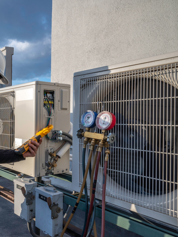 View of a red and blue testing unit with a commercial air conditioning unit.