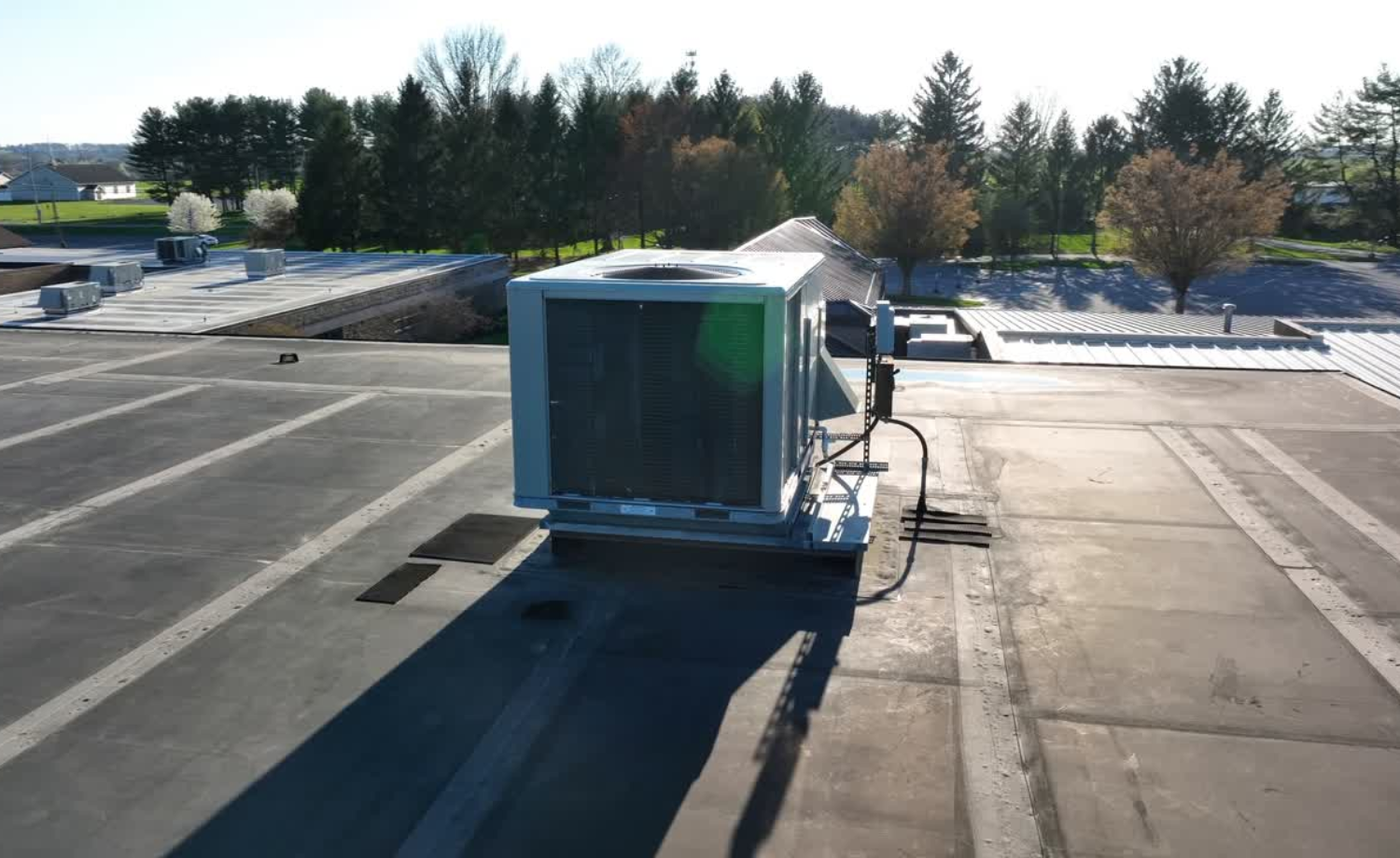 View of a commercial air conditioning unit on a building during sunrise.