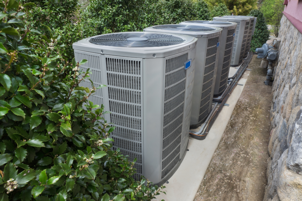View of three vertical air conditioning units on the side of a property.